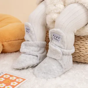 Detail view of light grey plush baby walking shoes with soft soles and velcro straps