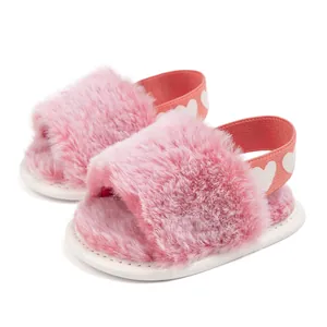 Detail view of pink plush baby sandals with white heart elastic strap and soft sole