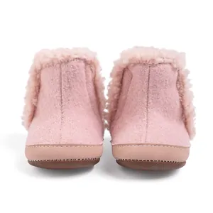 Detalle de botas de nieve rosas para bebé con ribete de piel sintética y suela antideslizante