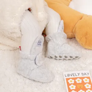 Detail of warm grey baby fleece shoes with anti-slip dotted soles and velcro closure