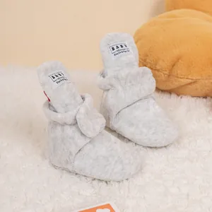 Detail of warm grey plush baby boots with adjustable velcro strap and soft fleece lining