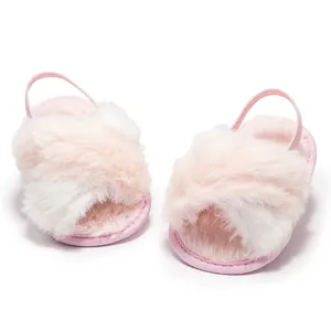 Close-up of pink fluffy baby slippers with cross straps and elastic back band
