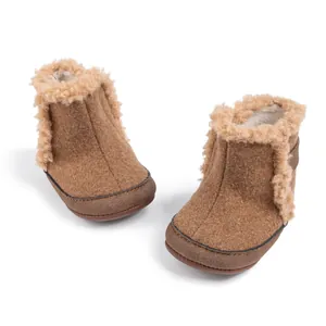 Detalle de botas de invierno marrones para bebé con forro de felpa suave y textura fieltro