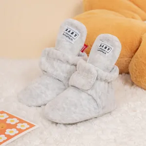 Close-up of baby winter boots with grey plush material and secure velcro strap closure