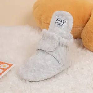 Detail of grey plush baby walking shoe with secure hook and loop fastener