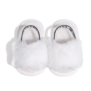 Detail of white plush baby sandals with soft faux fur and elastic heel strap support