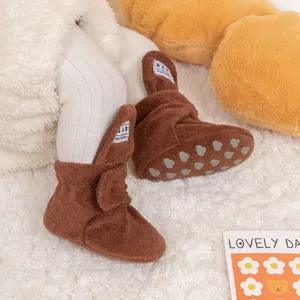 Detail of dark brown baby winter shoes featuring non-slip heart patterns on the sole
