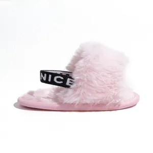 Close-up of pink faux fur baby slippers with an elasticated NICE letter strap