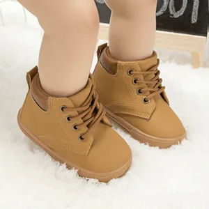 Close-up of baby brown high-top faux leather sneakers on a soft white plush rug