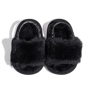 Close-up of soft black plush baby slippers with elastic heel strap and fluffy texture