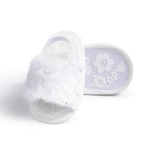 Detail of white plush baby slipper with silver sparkles and elastic heel strap