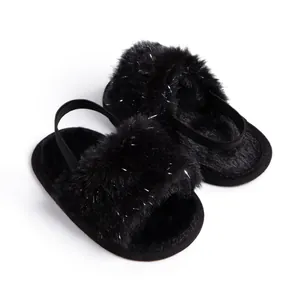 Detail of infant fuzzy black sandals with silver sparkles and elastic ankle strap