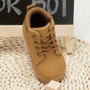 Close-up of children's tan PU leather lace-up boots with stitching details