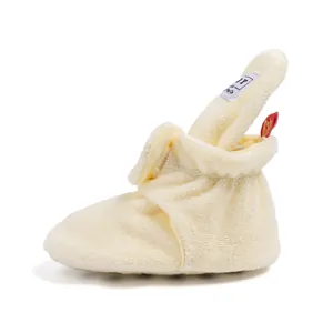 Detail view of cream plush baby walking shoes with side velcro closure and soft texture