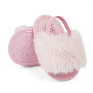 Detail of pink plush baby shoes with elastic heel strap and floral patterned anti-slip soles