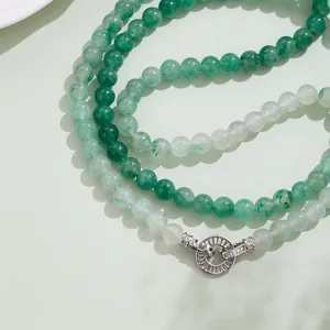 Detalle de un collar multicapa de jade verde de 8mm con cierre de plata y diamantes