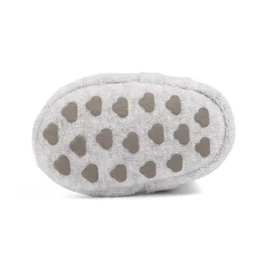 Close-up of soft grey baby shoes featuring anti-slip heart-shaped rubber dots on the sole