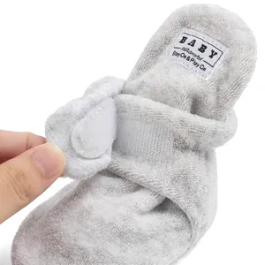 Close-up of adjustable velcro strap and plush grey fabric on newborn walking shoes