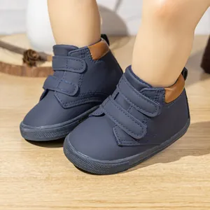 Detail view of navy blue soft-sole toddler shoes with double hook-and-loop straps and non-slip base
