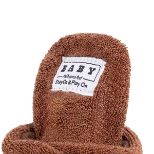 Detailed macro view of soft brown terry cloth fabric and Baby label on infant booties
