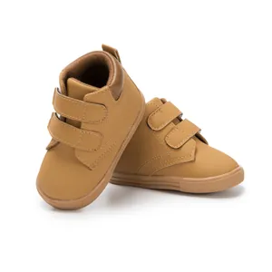 Detail of light brown toddler sneakers with dual hook-and-loop straps and anti-slip rubber sole