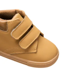 Detailed macro view of the synthetic leather surface and dual Velcro straps on kids shoes