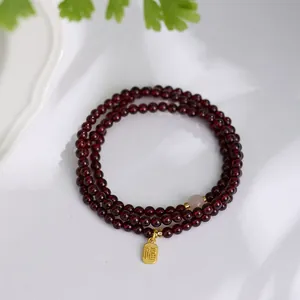 Three-layer garnet bead bracelet with golden Fu character pendant and nephrite jade charm