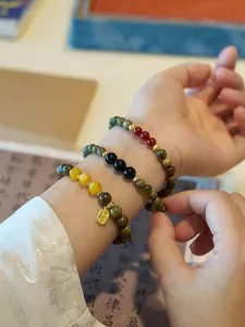 Detailed view of green sandalwood beads bracelet set with lucky pendant and jade charms