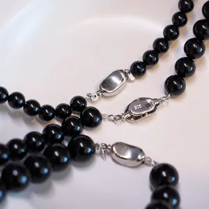 Macro shot of 925 sterling silver clasp on a natural black onyx beaded necklace