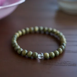 Macro detail of sandalwood beads with natural texture and a clear crystal charm