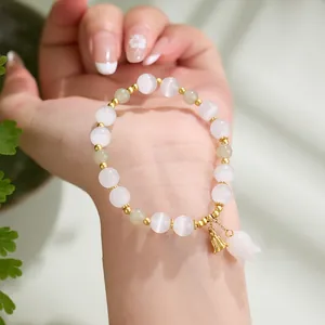 Elegant lily of the valley bracelet with cat eye stones and green beads on wrist