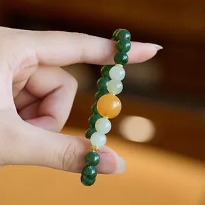 Macro shot of natural jasper beads with amber centerpiece and gold floral spacers