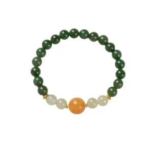 Natural jasper and amber bead bracelet with golden accents and oriental charm design