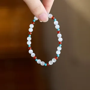 Detailed view of cat eye beaded bracelet with translucent white and reddish-brown stones