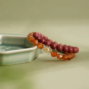 Details von roten Zinnober- und facettierten orangefarbenen Agat-Armbändern mit Anhängern