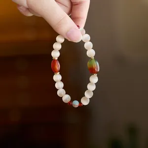 Macro shot of white cat eye stone bracelet with red agate and gold metal spacers