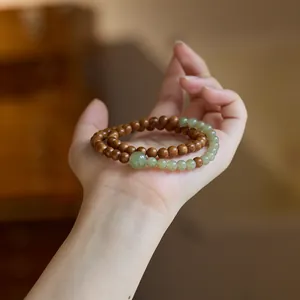 Λεπτομέρεια από βραχιόλι Kuka Bodhi και Hetian Jade διπλής περιέλιξης κρατημένο στο χέρι