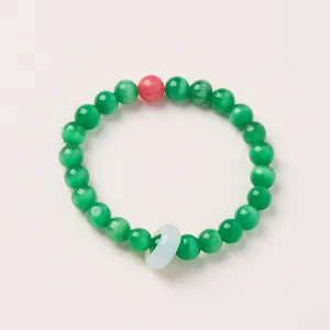 Close-up of green cat's eye beads with red accent and pale green ring on a beaded bracelet