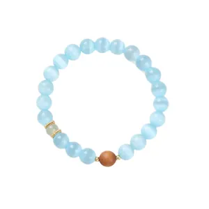 Cat eye bead bracelet featuring light blue stones and a wooden accent on white background