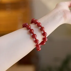Detail eines zwelagigen roten Achat-Perlenarmbands mit Politur am Handgelenk der Frau