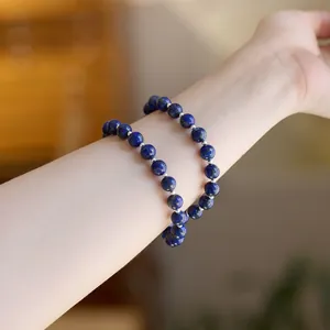 Lapis-Lazuli Armband mit tiefblauen Perlen und silbernen Trennelementen am Handgelenk