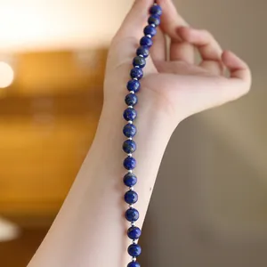 Nahaufnahme eines zweilagigen Armbands und einer Kette aus rotem Achat am Handgelenk