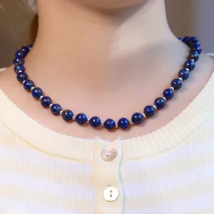 Nahaufnahme der Lapislazuli-Perlenkette mit Silberzwischenperlen am Hals getragen