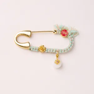 Detail einer Vintage-Gold-Pferdebrosche mit buntem Faden und Jadewulst-Anhänger-Dekor