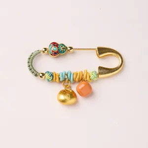 Detail of a Chinese gold horse year safety pin brooch with enamel gourd and fuzhou lock