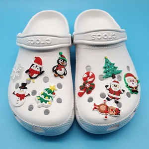 White clogs decorated with Christmas penguin, snowman, and reindeer PVC shoe charms