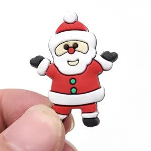 Detailed view of 3D PVC Santa Claus shoe charm for clog sandals held by fingers