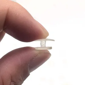 Hebilla de base transparente de plástico para zapatos de jardín sostenida entre los dedos