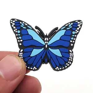 Detailaufnahme eines blauen PVC Schmetterling Schuhanhängers für Clogs mit Befestigungsknopf