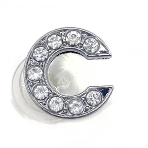 Close-up of letter C shoe charm with inlaid white zircons and silver alloy finish